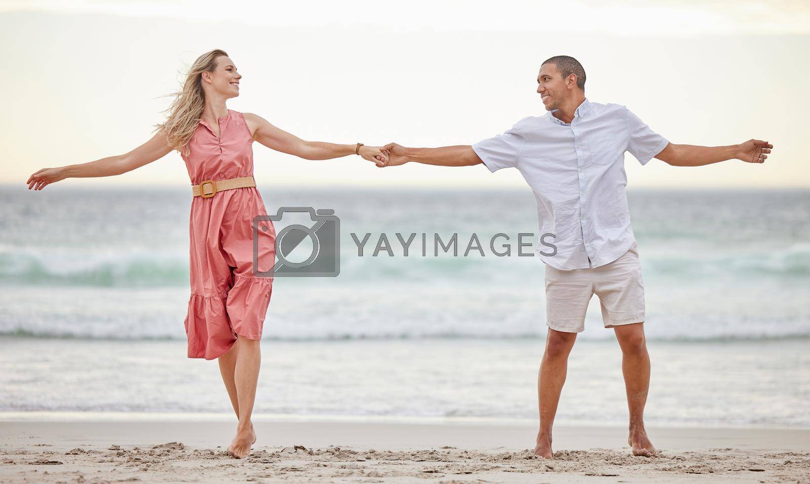 Royalty free image of Love, beach and couple happy, smile and romance, care and marriage relationship together. Summer, holiday and happiness with man and woman by the sea on travel vacation trip for freedom or honeymoon by YuriArcurs
