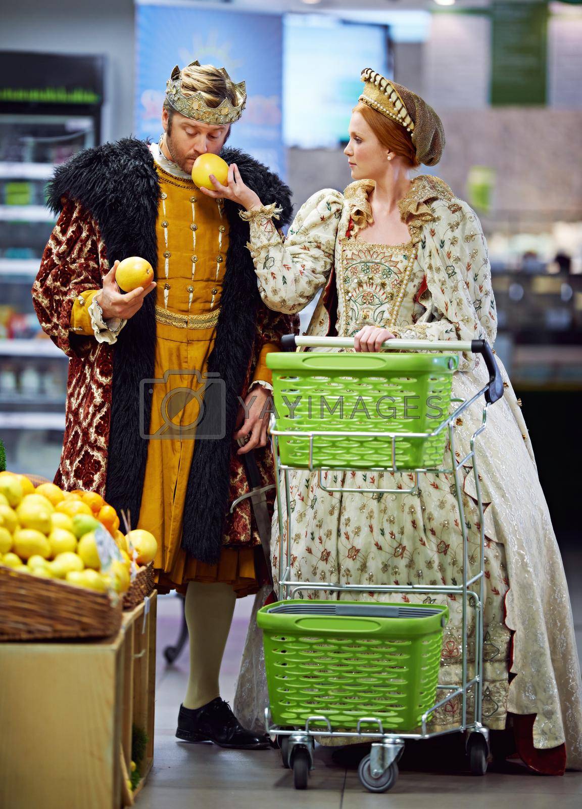 Royalty free image of This is why one has servants to do the shopping....A king and queen buying groceries in a groceries store. by YuriArcurs