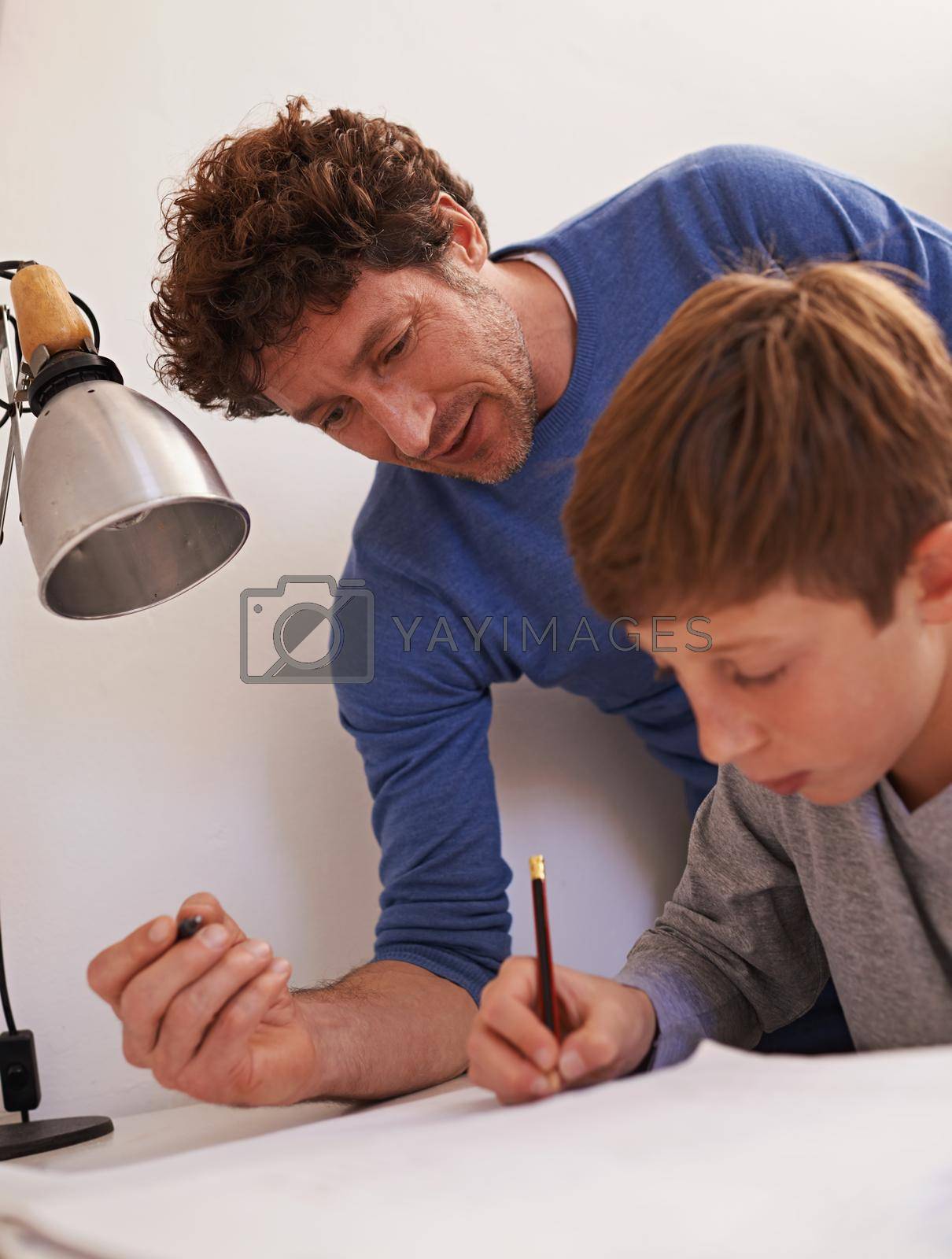 Royalty free image of Keeping an eye on his studies. a teenage boy getting some study help from his father. by YuriArcurs
