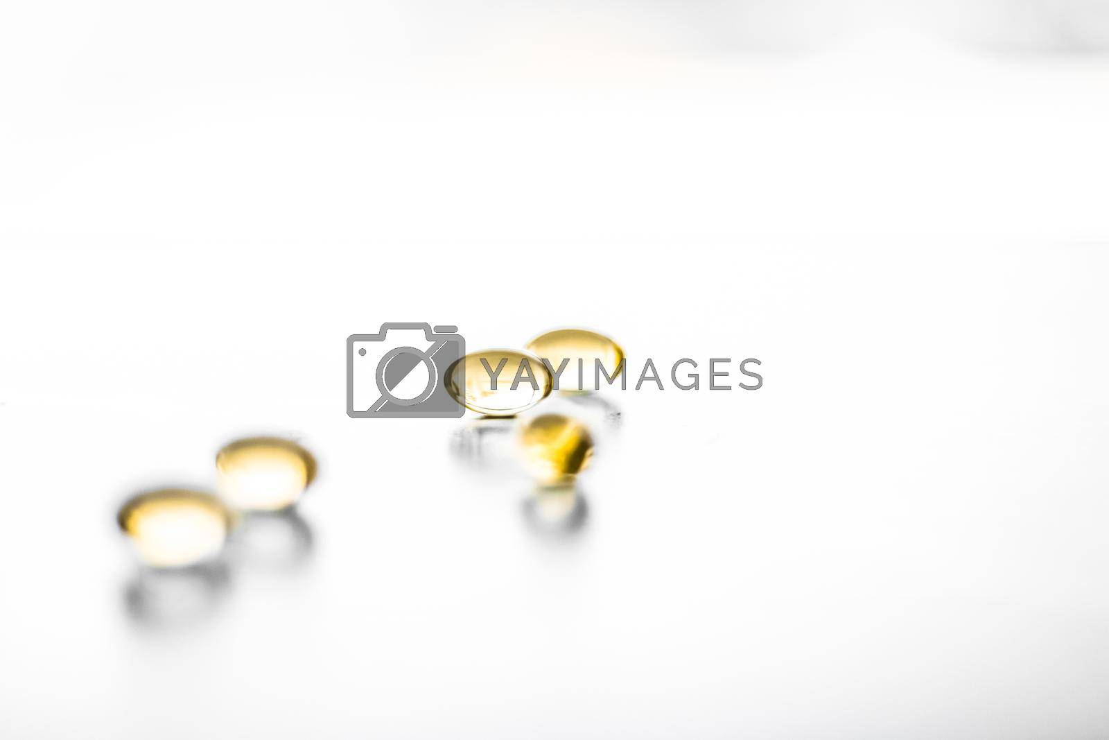Royalty free image of Vitamin D and golden Omega 3 pills for healthy diet nutrition, fish oil food supplement pill capsules, healthcare and medicine as pharmacy background by Anneleven