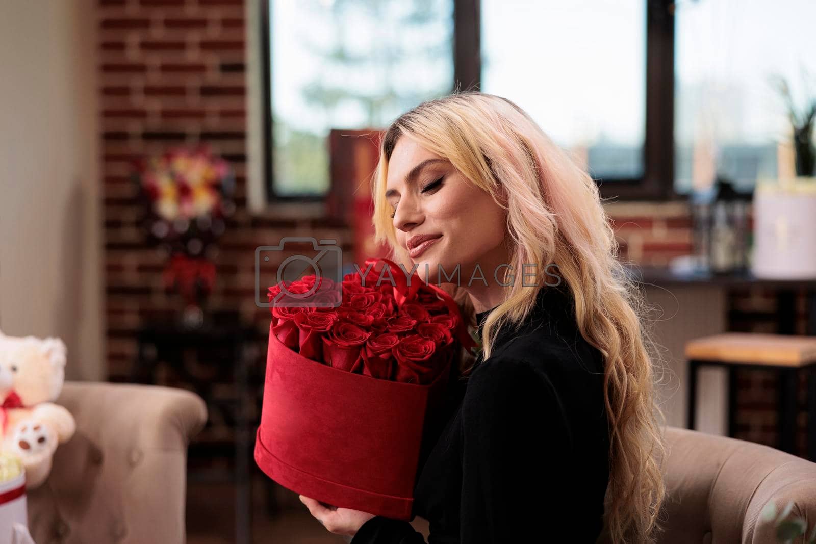 Royalty free image of Woman holding valentines day red roses box by DCStudio