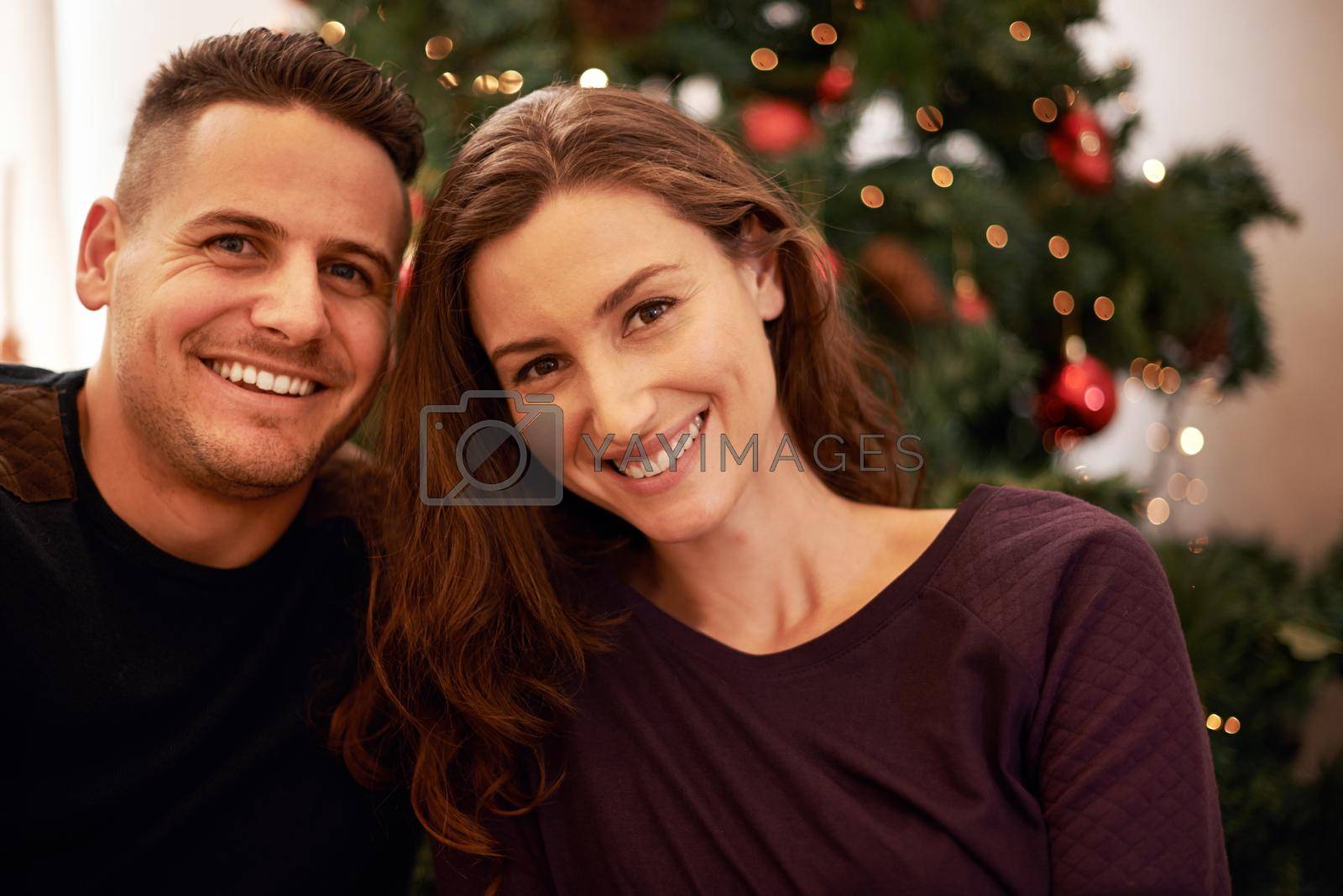 Royalty free image of Our first Christmas together. Portrait of a happy young couple on Christmas day. by YuriArcurs
