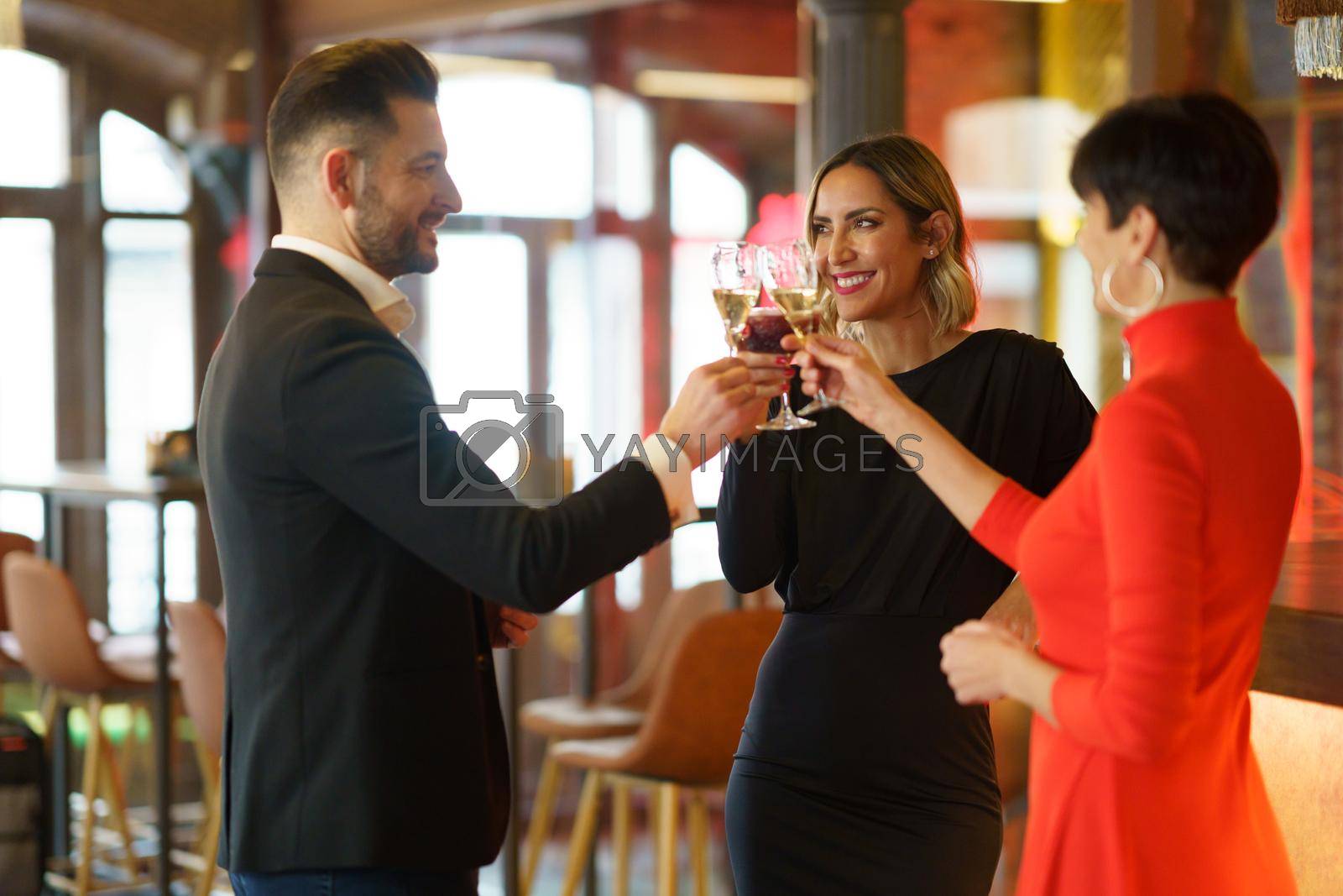 Royalty free image of Delighted friends clinking glasses in an elegant restaurant by javiindy