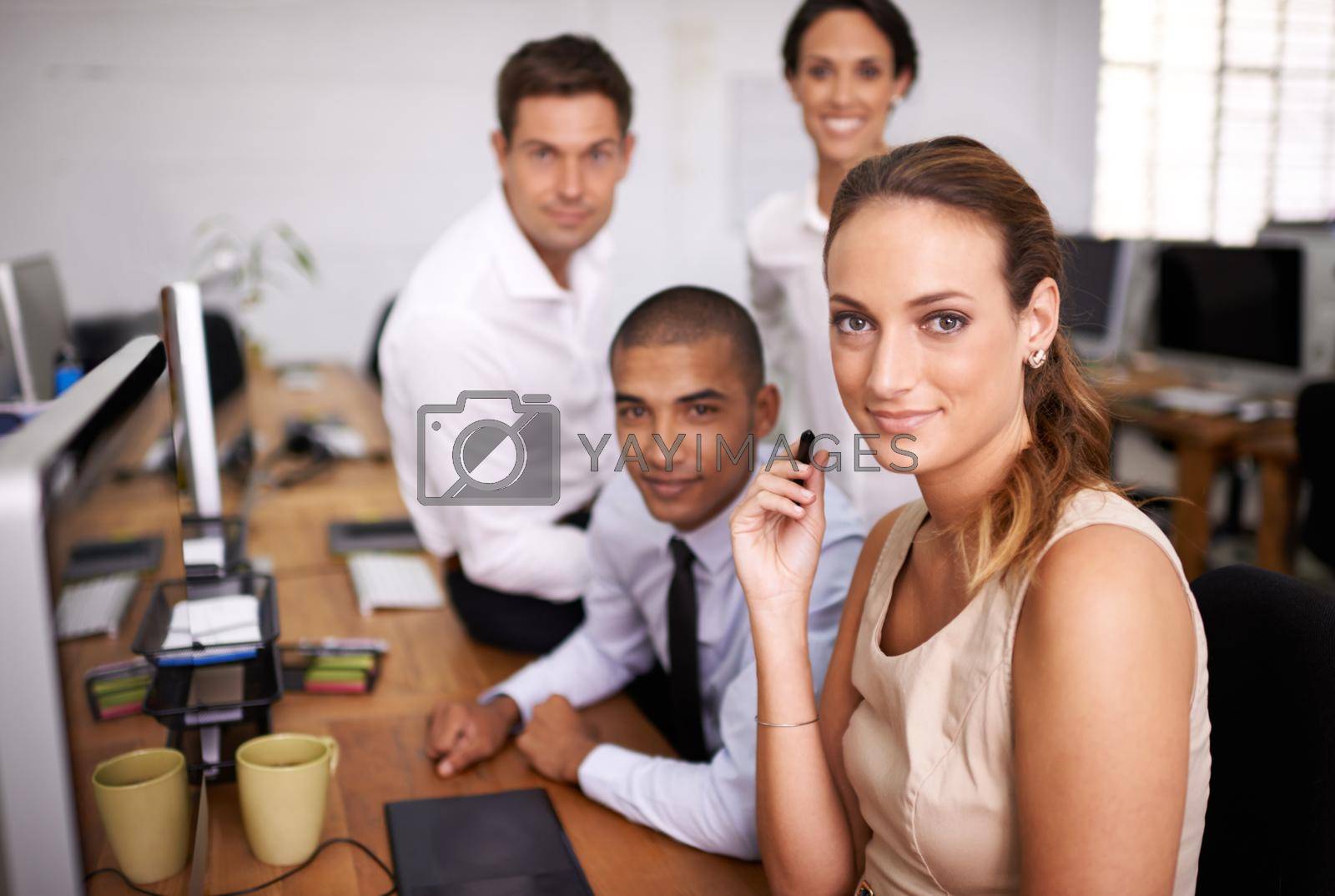 Royalty free image of We make teamwork look easy. Portrait of a happy business team working at a desk together. by YuriArcurs