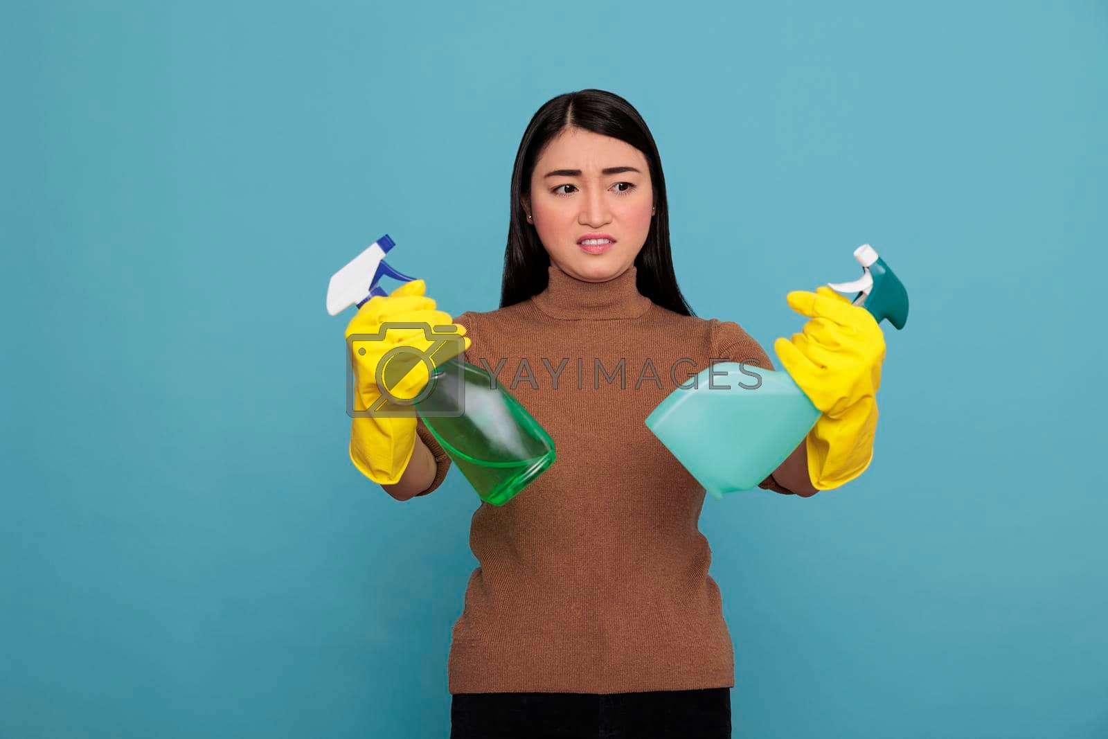 Royalty free image of Asian young inactive dull housekeeper from chores by DCStudio