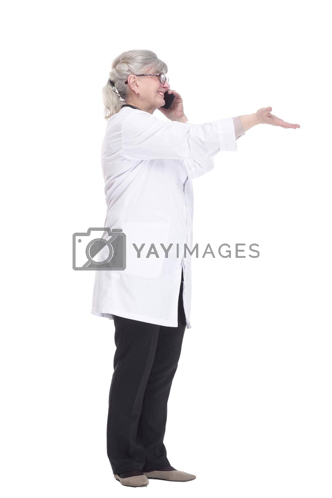 Royalty free image of female doctor with a smartphone pointing at an ad on a white wall . by asdf