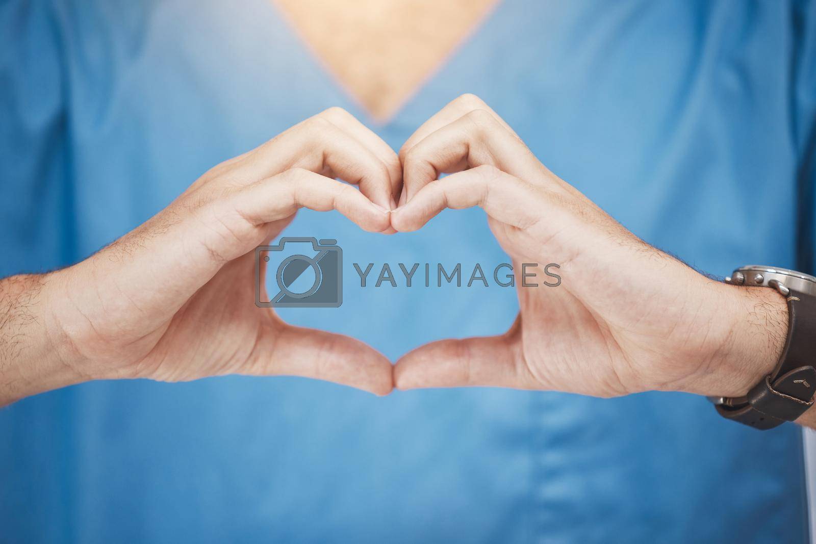 Doctor or nurse make heart sign, with hands to show care or compassion. Woman worker in healthcare show love icon with fingers, as expression of love for their job or wellness of patients.
