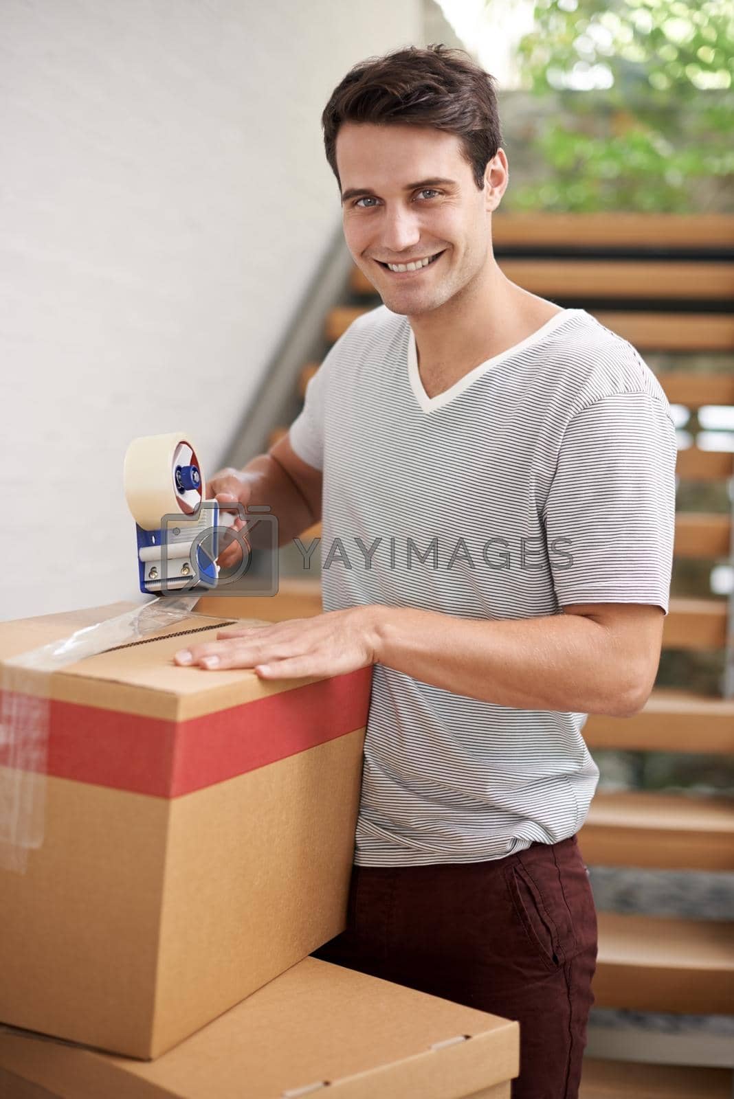 Royalty free image of Packing up and rearing to go. A happy young man packing cardboard boxes in his home. by YuriArcurs