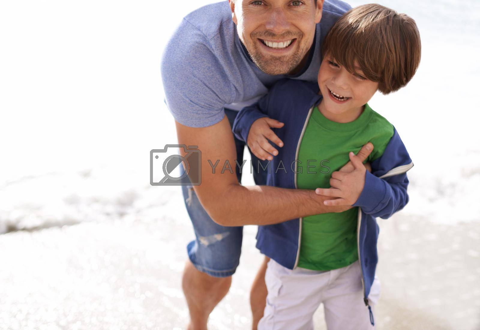 Royalty free image of Father and son bonding time. A father playing with his son at the beach. by YuriArcurs