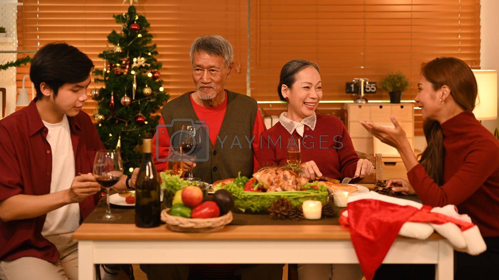 Royalty free image of Group of people enjoying Thanksgiving meal in comfortable home. Celebration, holidays and Christmas concept by prathanchorruangsak