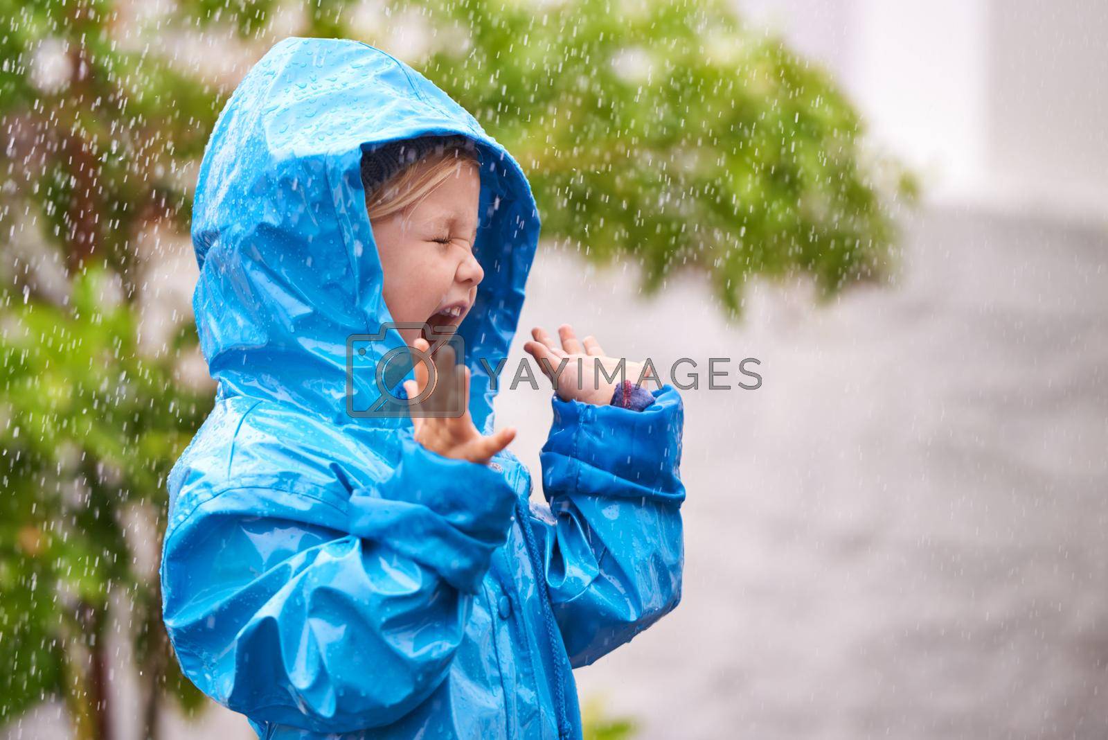 Royalty free image of To enjoy the rainbow, first enjoy the rain. a young girl playing outside in the rain. by YuriArcurs