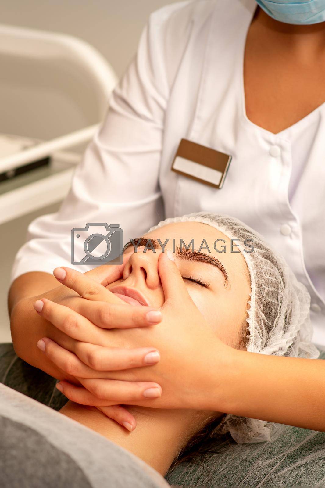 Royalty free image of Beautiful young caucasian woman with closed eyes receiving a facial massage in a beauty salon. by okskukuruza