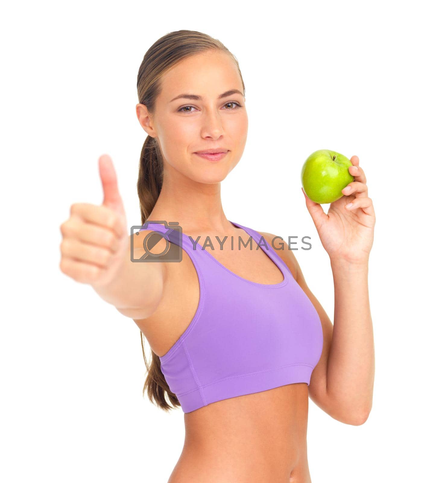 Royalty free image of Giving a big thumbs up to a healthy lifestyle. Studio portrait of a sporty young woman holding an apple and giving you the thumbs up. by YuriArcurs