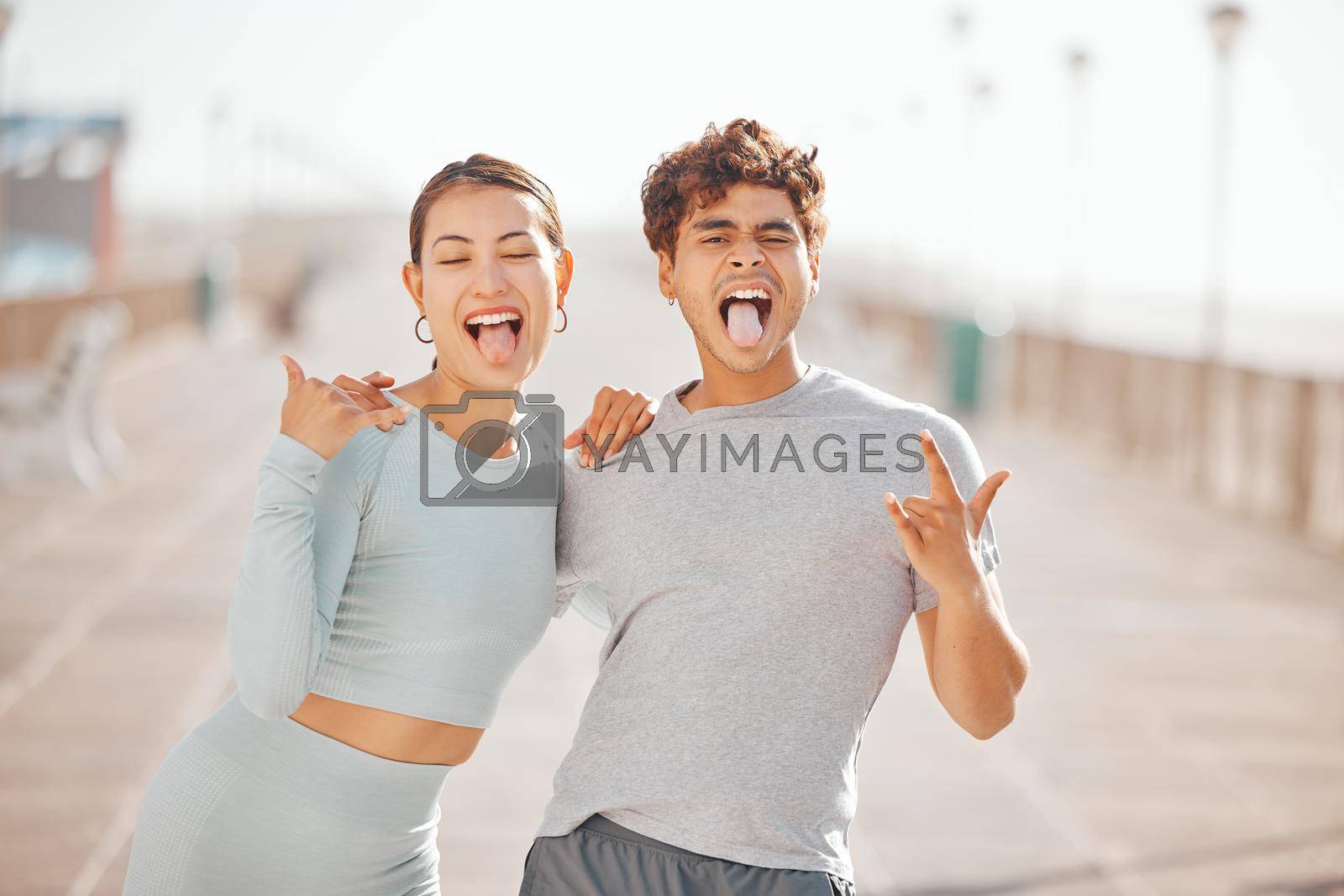 Royalty free image of Man and woman friends with tongue out, happy and crazy together in city after fitness workout outdoor in sunny summer. Funny, comic and Japanese Asian young people smile, hug and love for friendship by YuriArcurs
