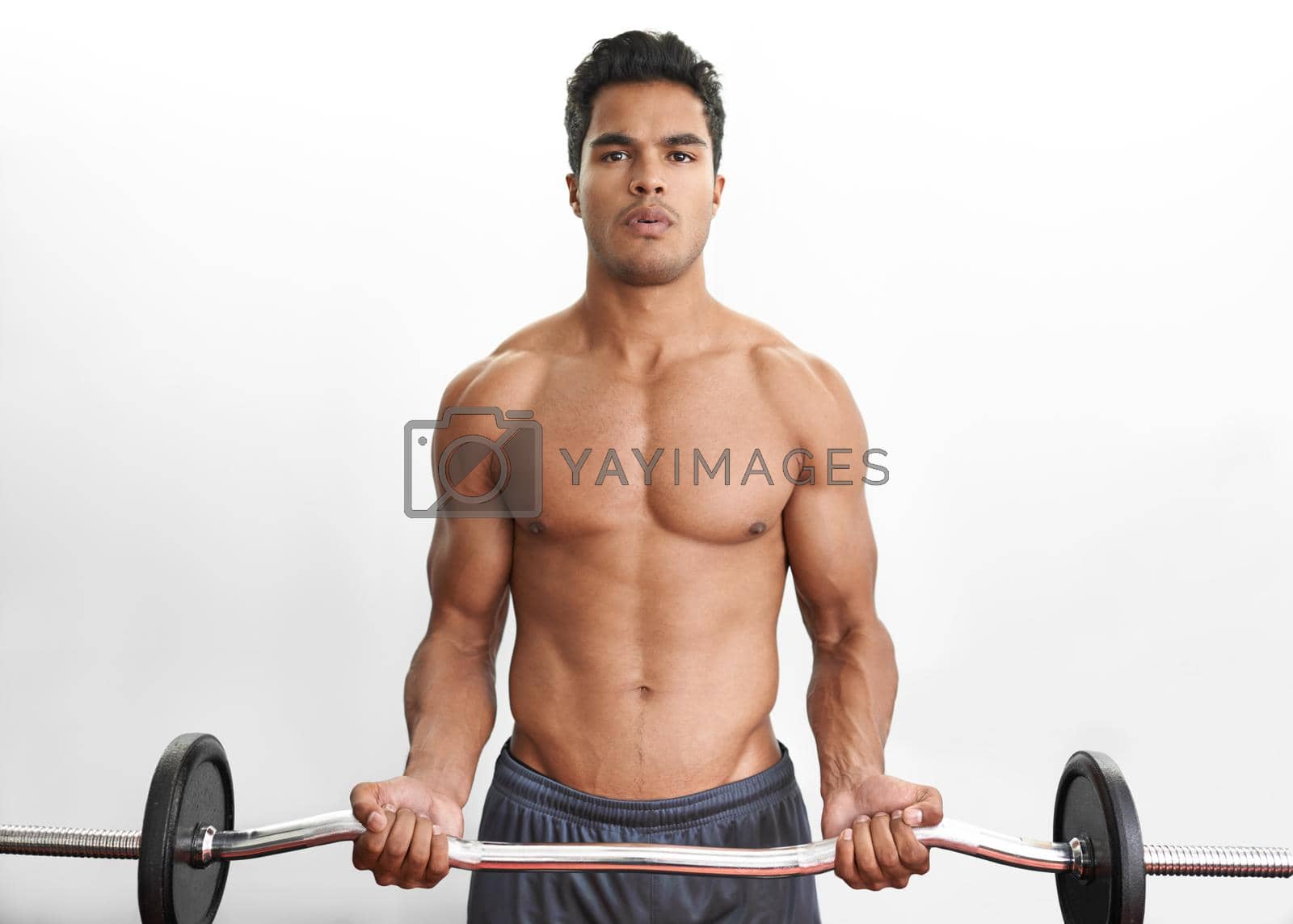 Royalty free image of Building his upper body strength. Studio portrait of an athletic young man lifting a barbell. by YuriArcurs