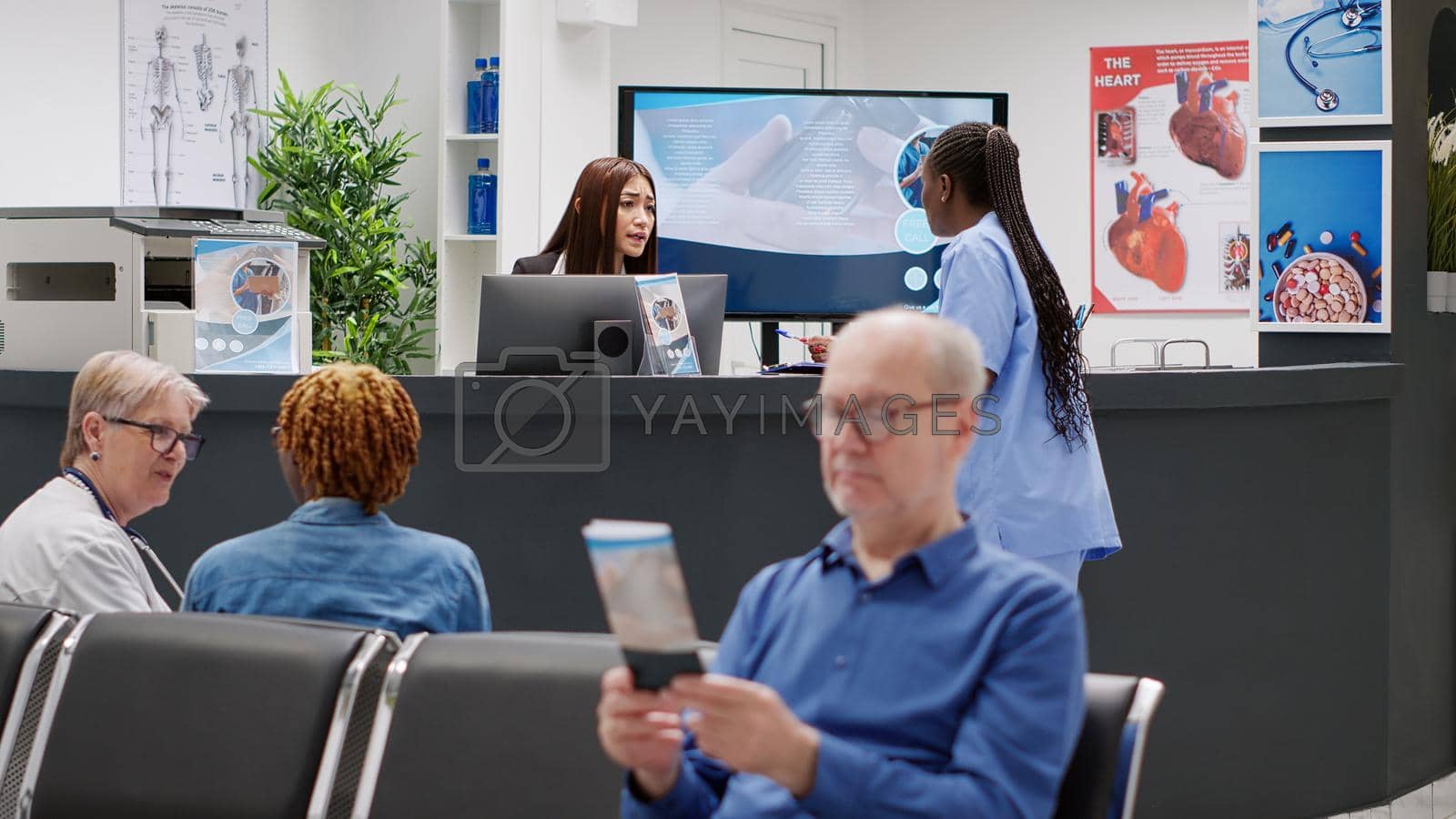 Royalty free image of Diverse medical staff working on appointments at reception desk by DCStudio