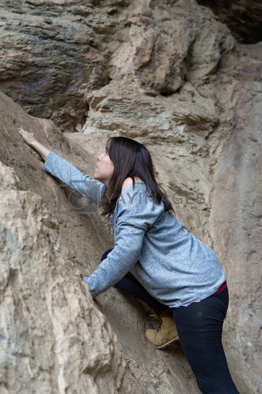 Royalty free image of young woman rock climbing by joseantona