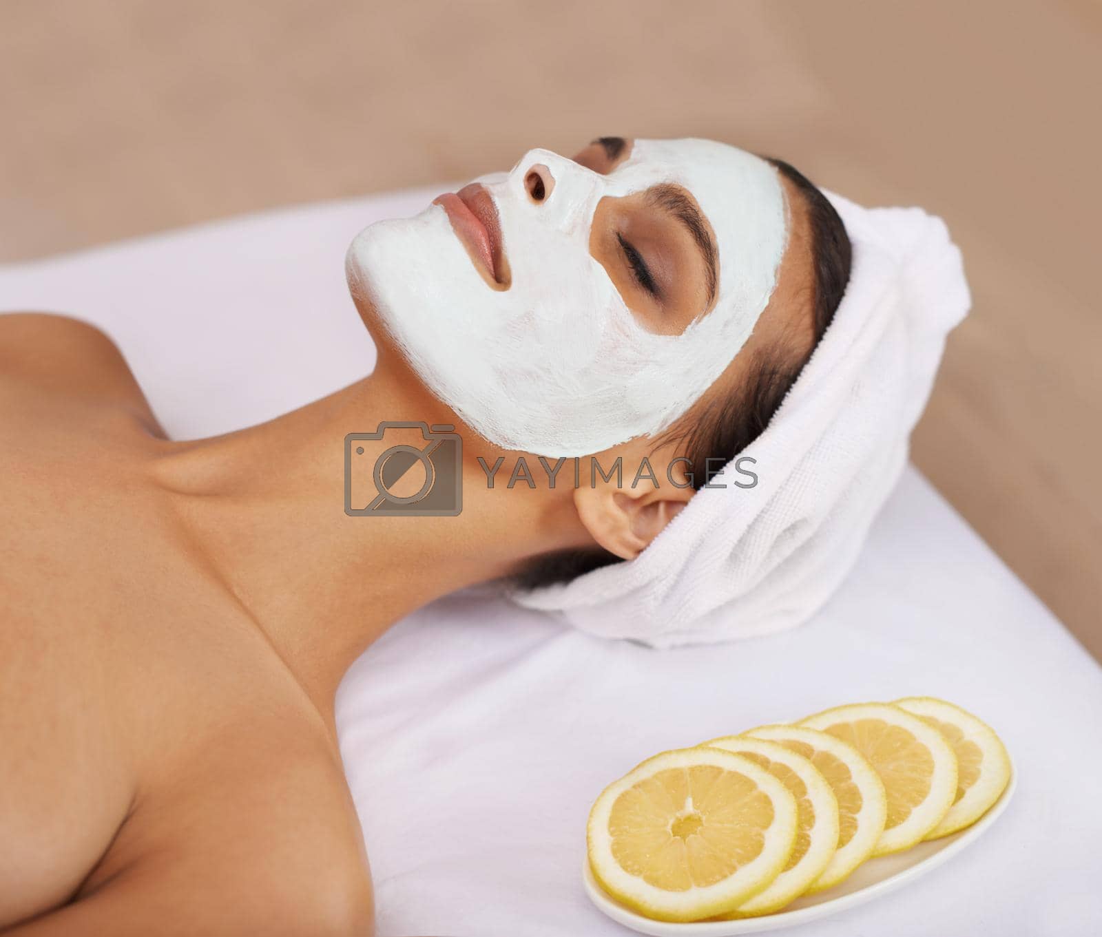 Royalty free image of Treating her skin to a pampering mask. a young woman enjoying a facial treatment at a spa. by YuriArcurs