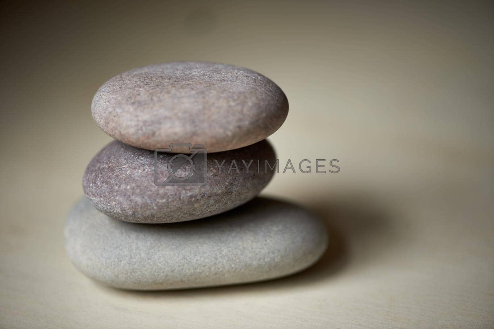 Royalty free image of Feeling balanced. Three stones balanced on top of each other in natural light. by YuriArcurs