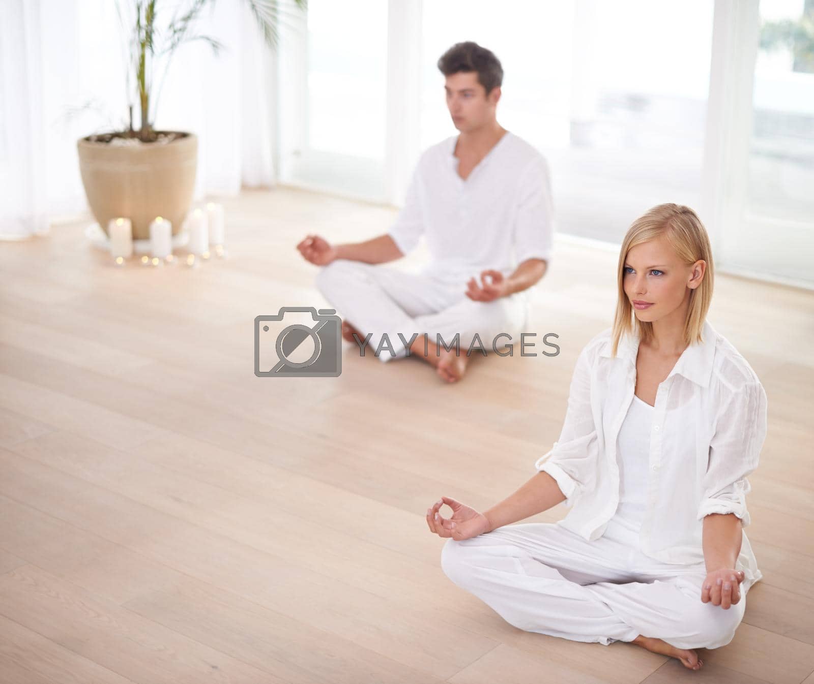 On their way to enlightenment...Two people sitting in the lotus position in a yoga studio