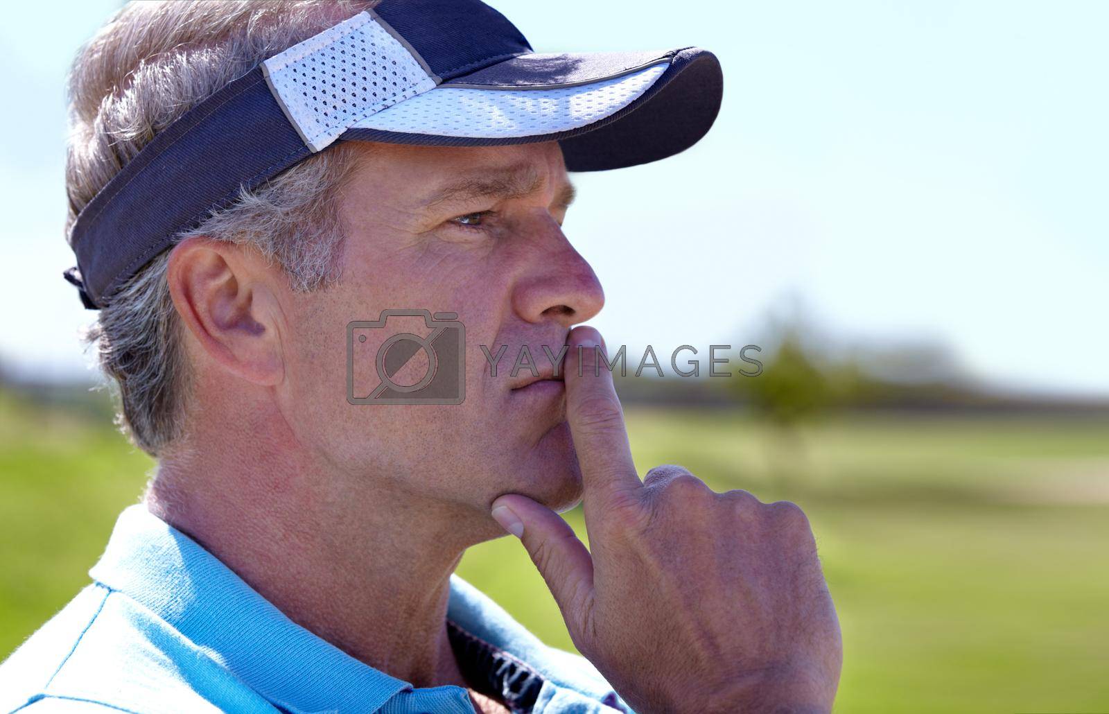 Royalty free image of Ive only got three shots left for par...Profile of a mature male golfer busy strategizing. by YuriArcurs