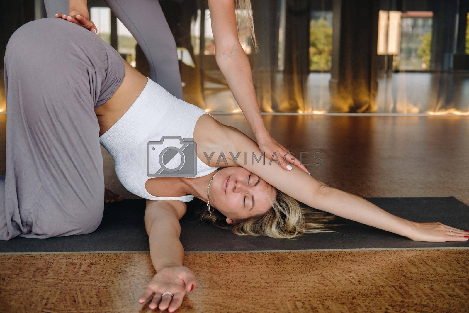 Yoga exercises. A personal trainer teaches a woman yoga classes in the gym.