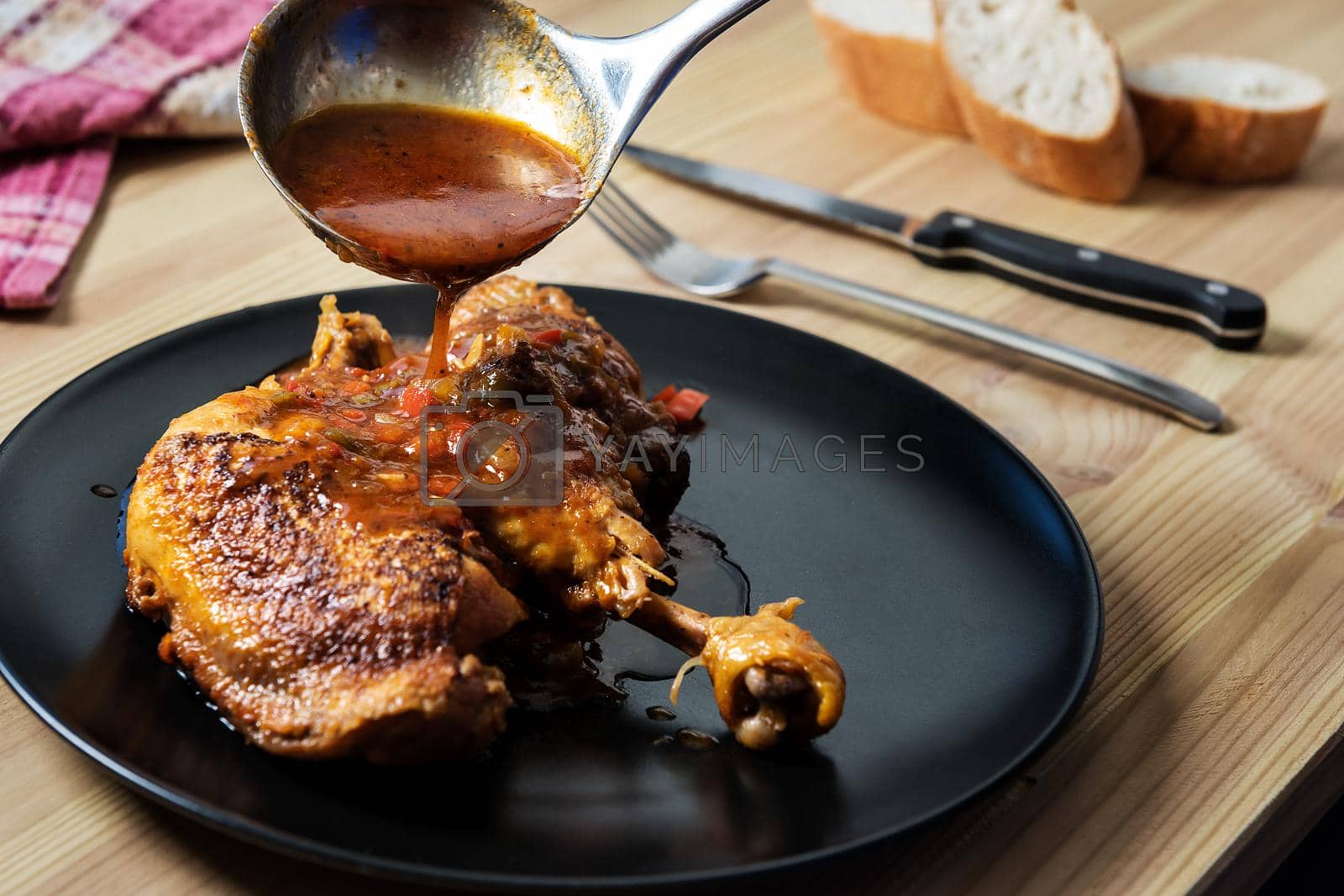 Royalty free image of ladle pouring garnish on the chicken by raulmelldo