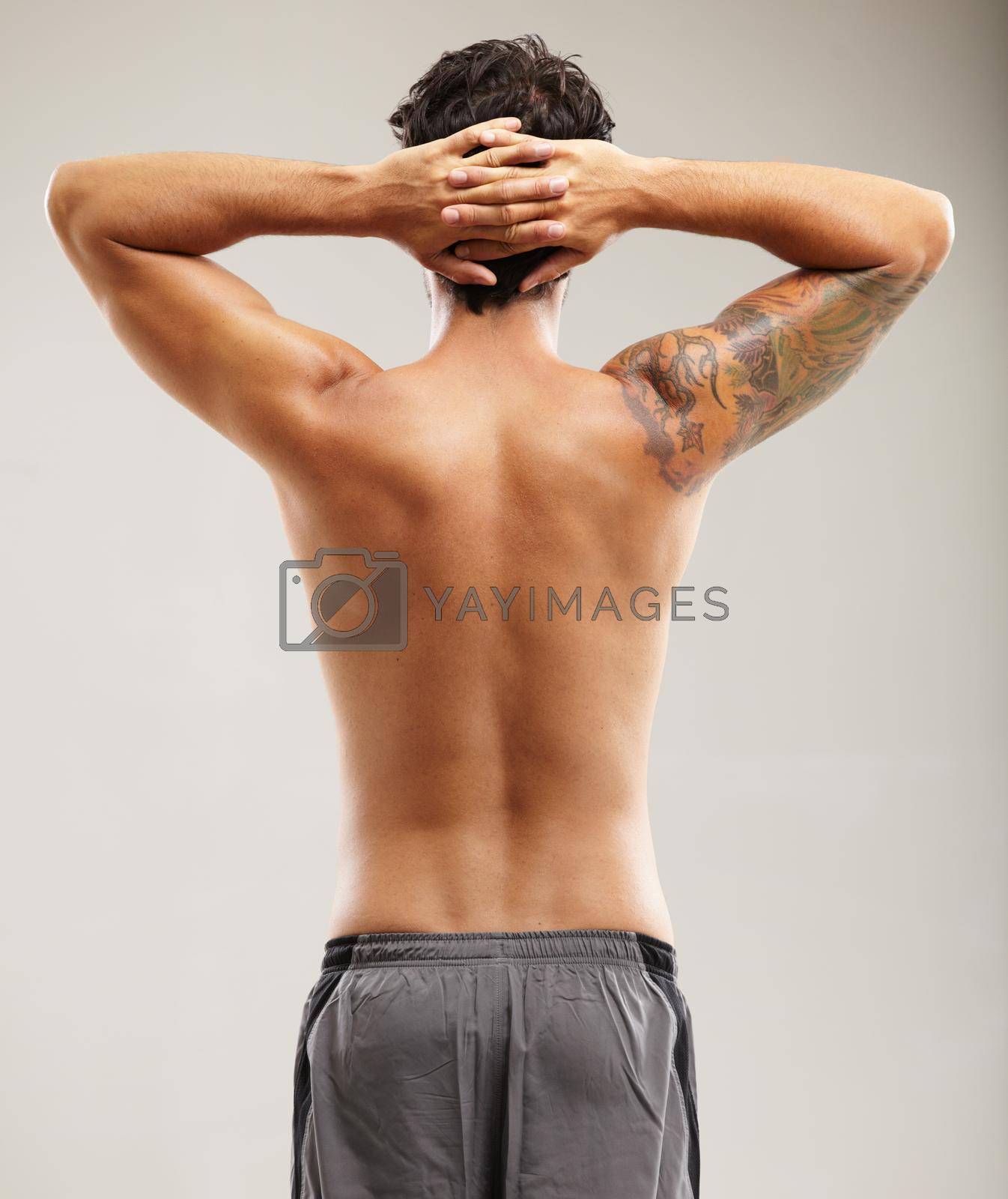 Royalty free image of He takes stretching seriously. Rearview of a shirtless man stretching his neck before a workout. by YuriArcurs