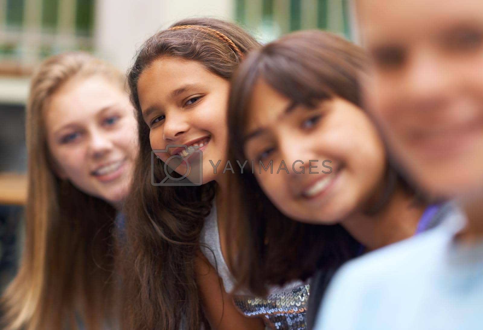 Royalty free image of Friendship and smiles. Portrait of a young girl standing amongst her school friends. by YuriArcurs