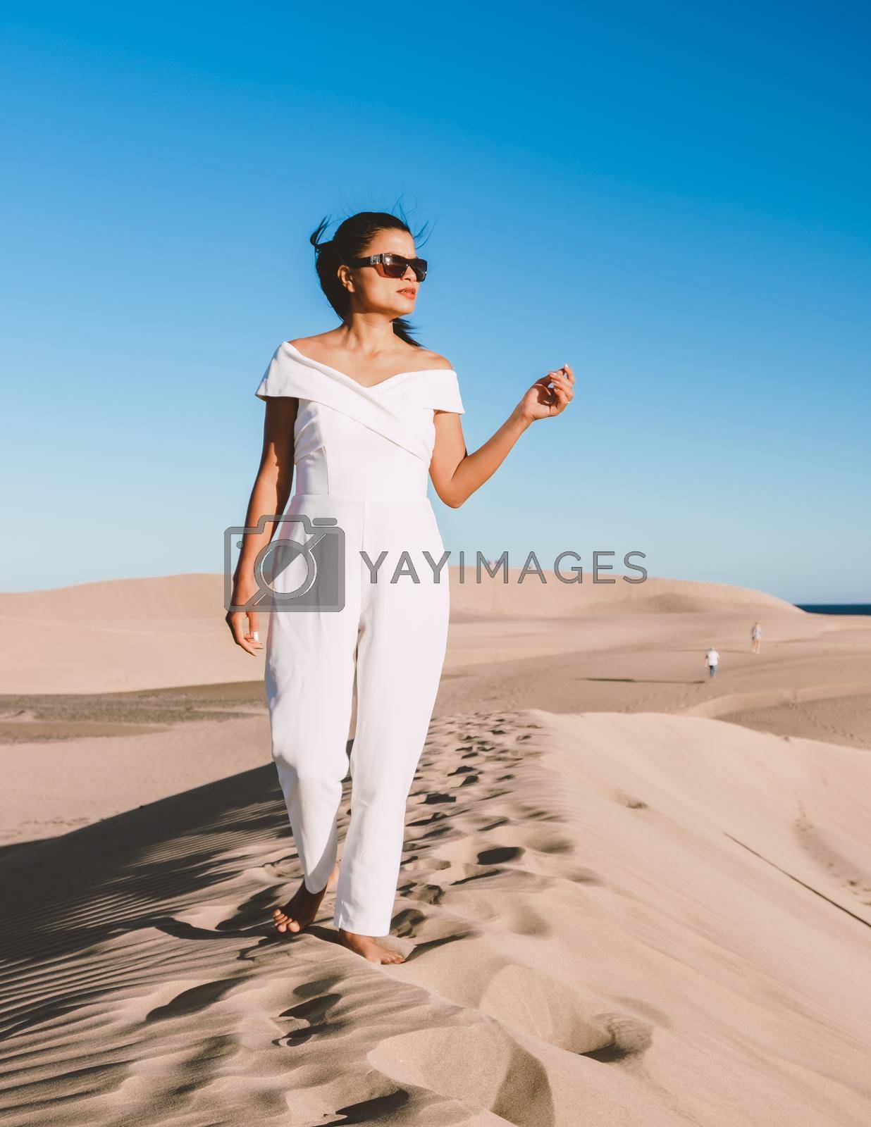 Royalty free image of young woman at the dessert of Maspalomas sand dunes Gran Canaria during vacation Canary Islands by fokkebok