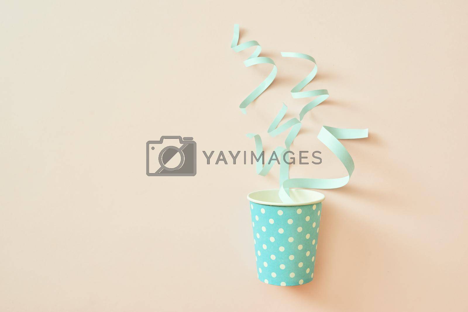 Celebration concept. Paper cup with confetti on a beige background. 