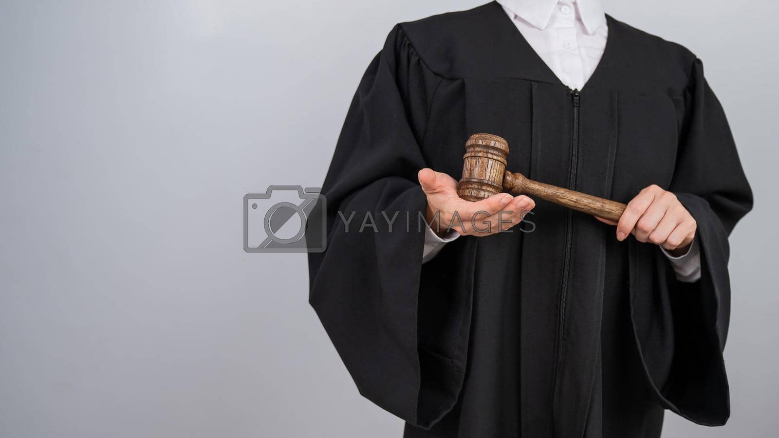 Royalty free image of Faceless female judge in a robe holding a court gavel. by mrwed54