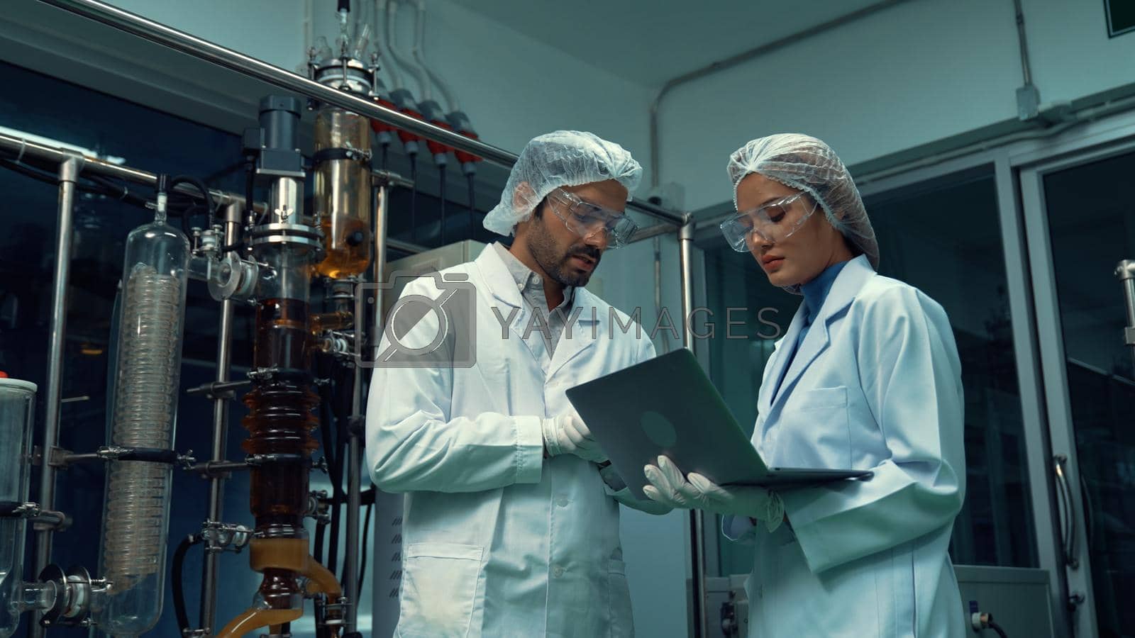 Royalty free image of Two scientist in professional uniform working in laboratory by biancoblue