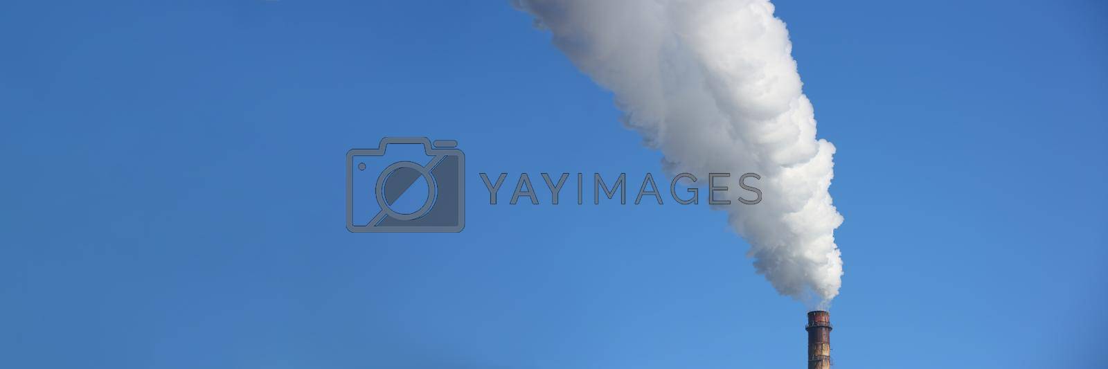 Royalty free image of Chimney blows white smoke into blue sky by kuprevich