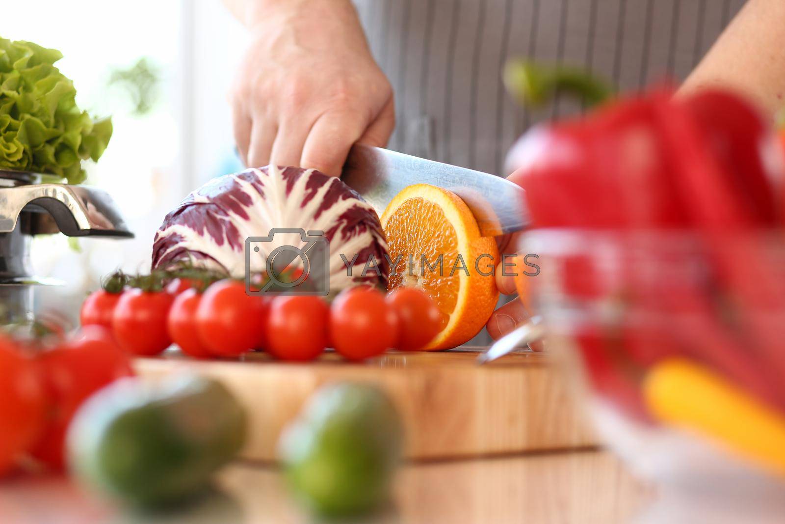 Royalty free image of Chef man cut vegetables and fruits on cutting board closeup by kuprevich