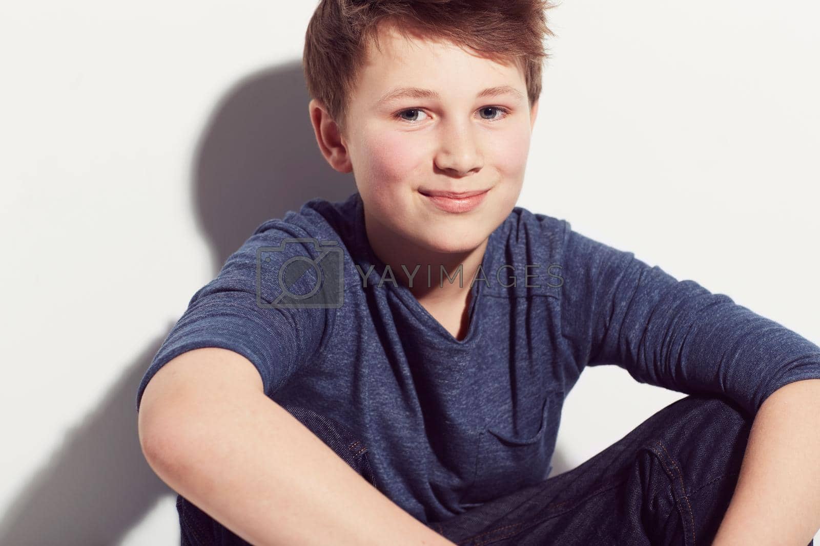 Royalty free image of Filled with potential. Young adolescent boy sitting against a white background with a smile. by YuriArcurs