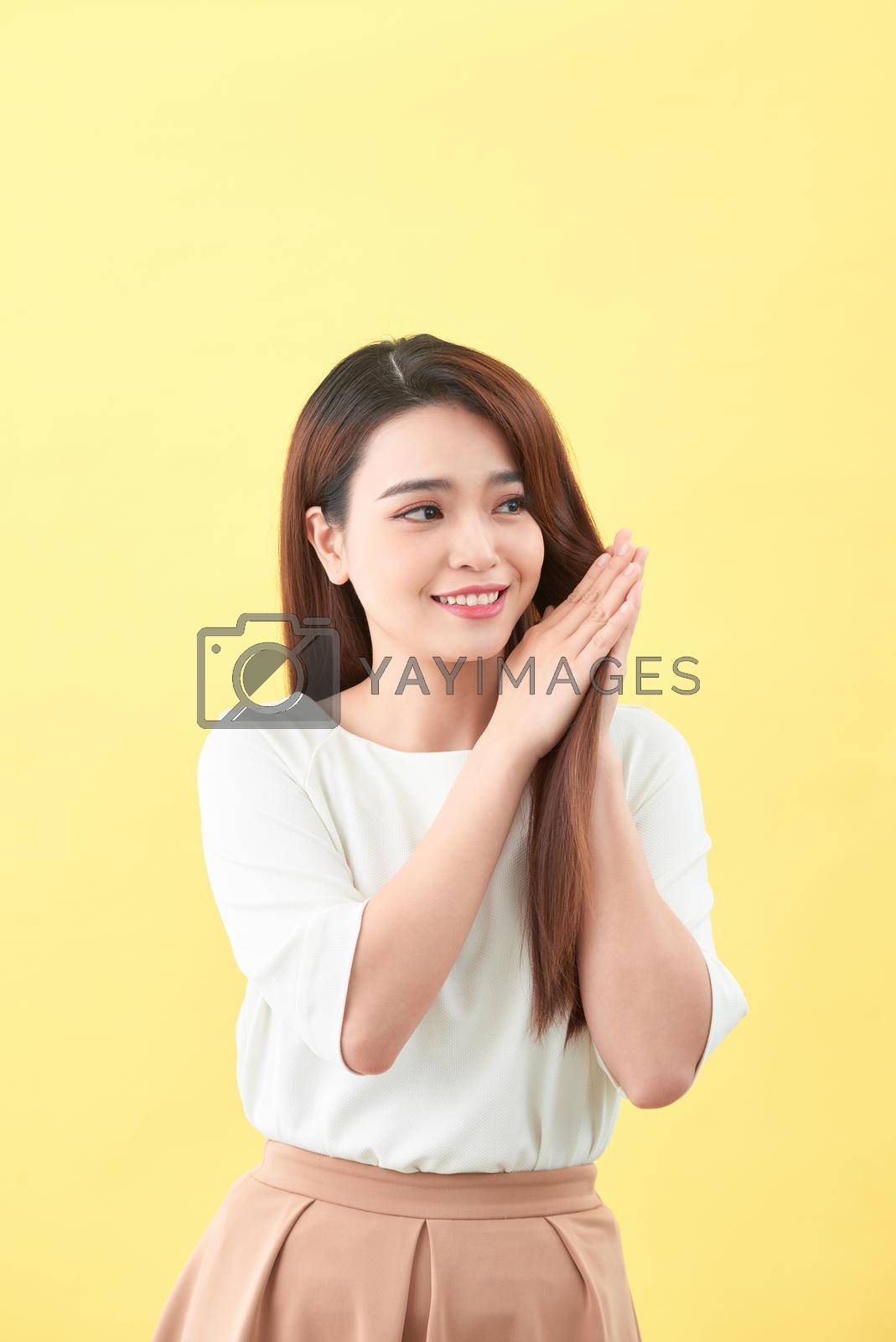 Beauty woman touch her long hair isolated on yellow background, asian beauty 