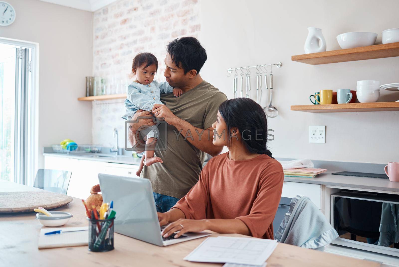 Royalty free image of Family, baby and down syndrome while mother work online with laptop in kitchen. Mom, father and child play while mother use computer for learning, education or college on the internet in house by YuriArcurs