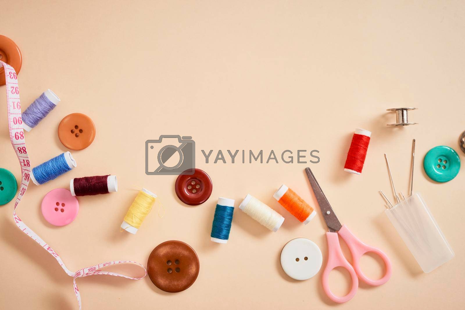 Royalty free image of tools for needlework thread scissors and tape measure isolated on biege background  by makidotvn
