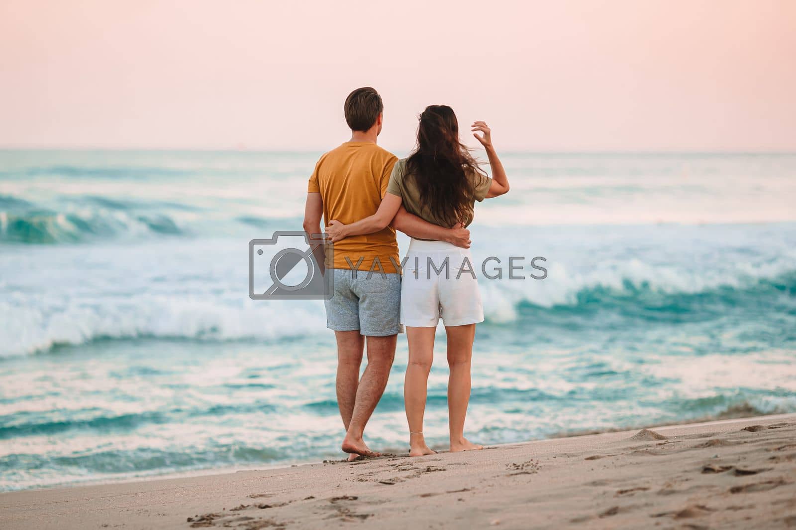 Royalty free image of Young couple on the beach vacation in Florida at sunset by travnikovstudio