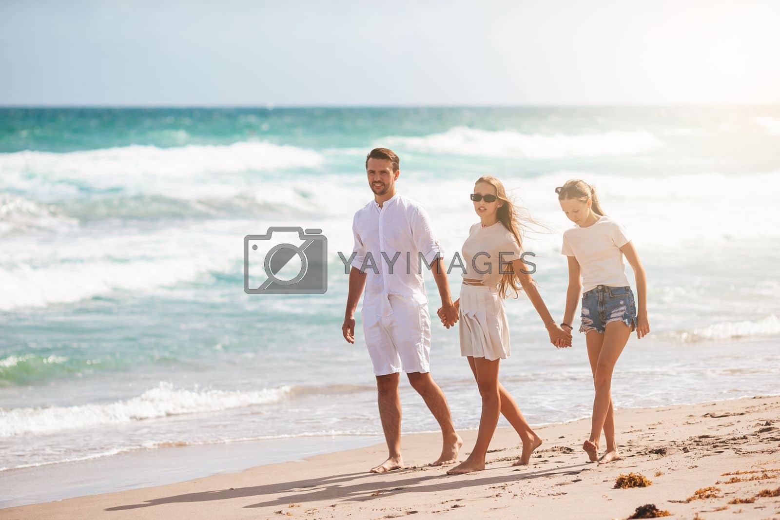 Royalty free image of Family of father and kids on the beach by travnikovstudio