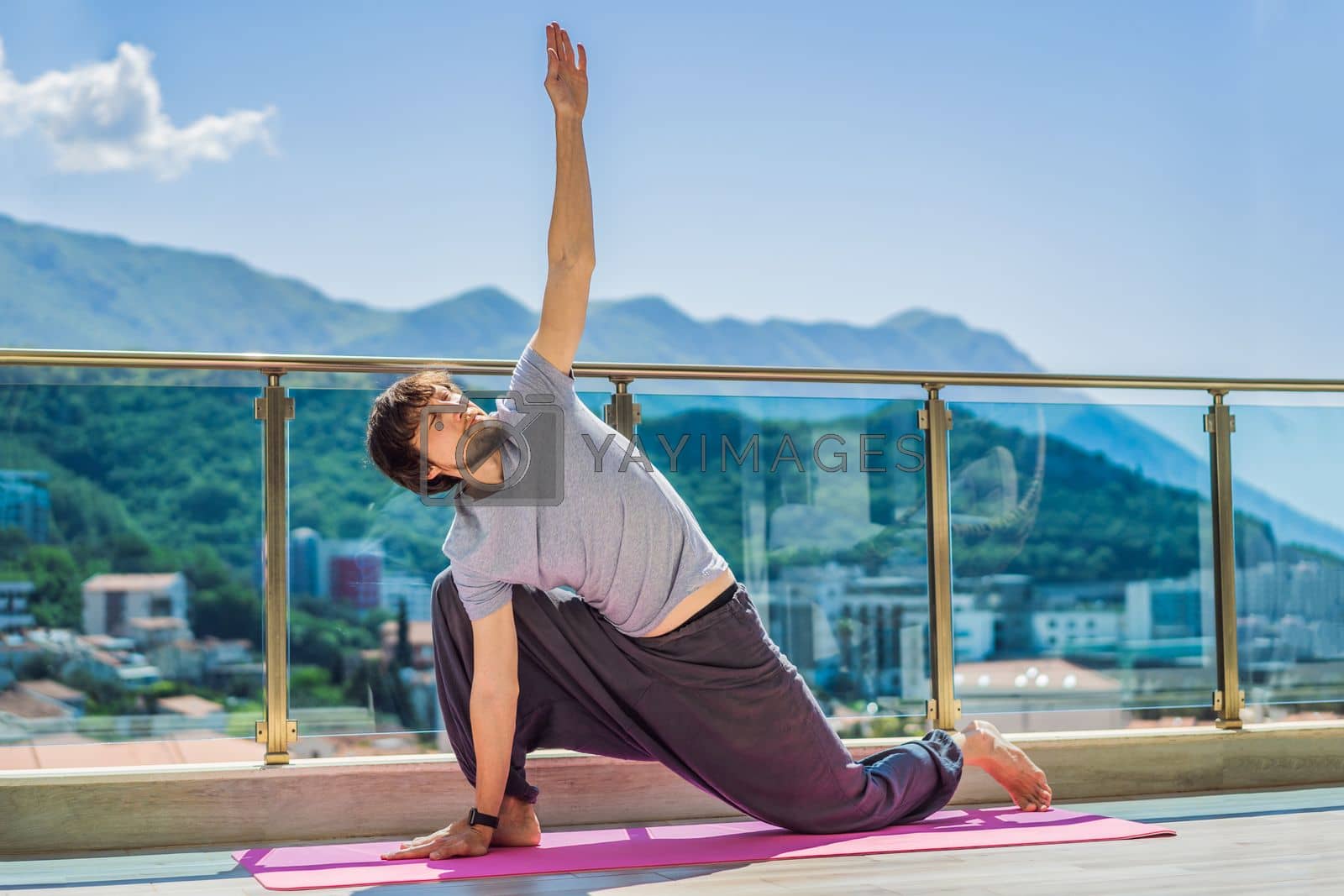 Royalty free image of Man doing yoga outdoors on a rooftop terrace by galitskaya