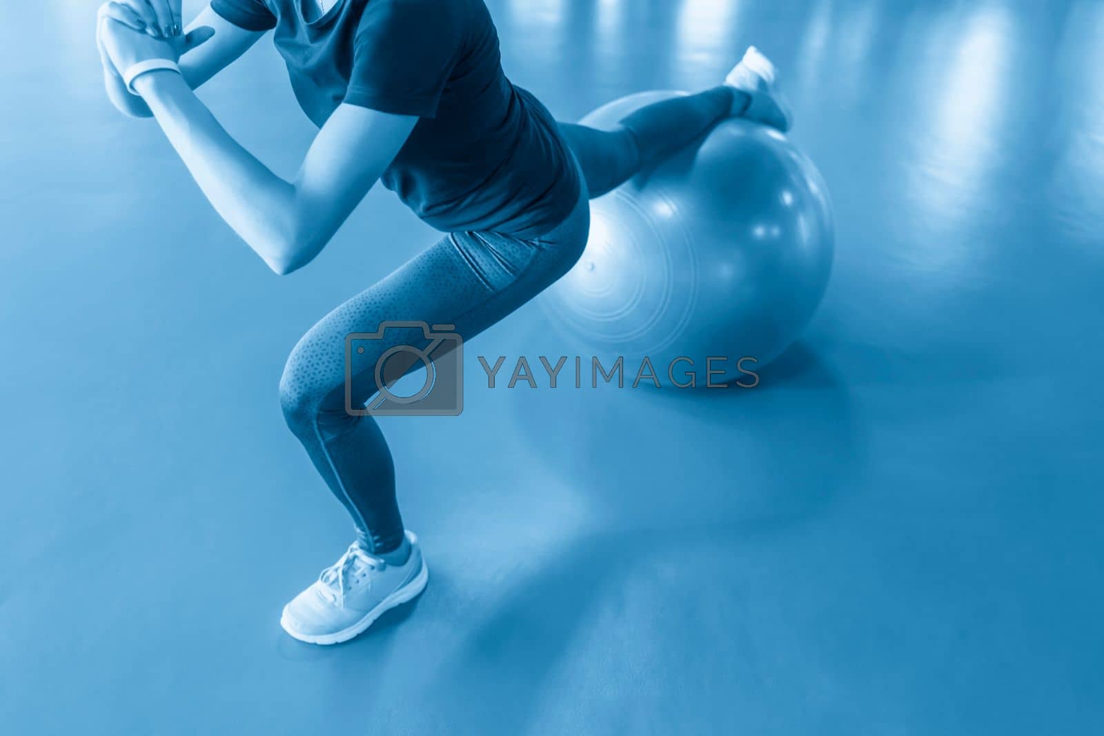 Royalty free image of Woman at the gym doing exercises with pilates ball by Mariakray