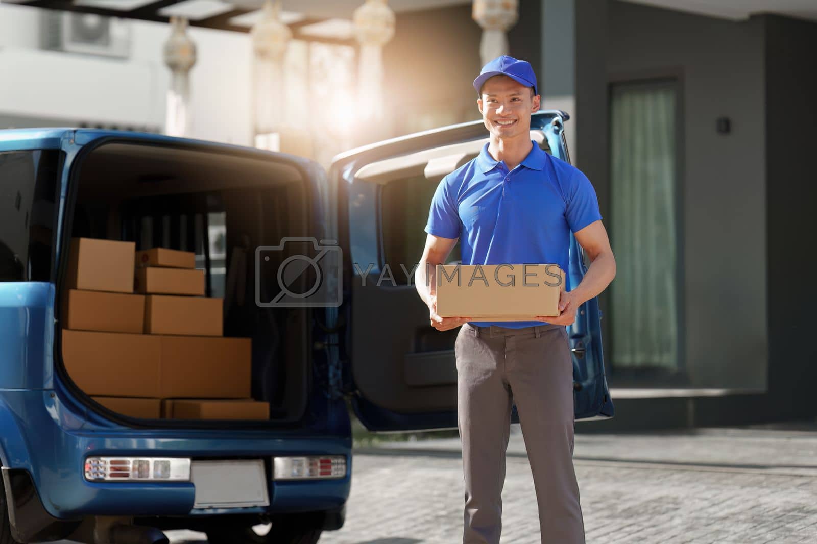Royalty free image of Asian courier with parcel and delivery logistic concept. Delivery man holding the parcel by itchaznong