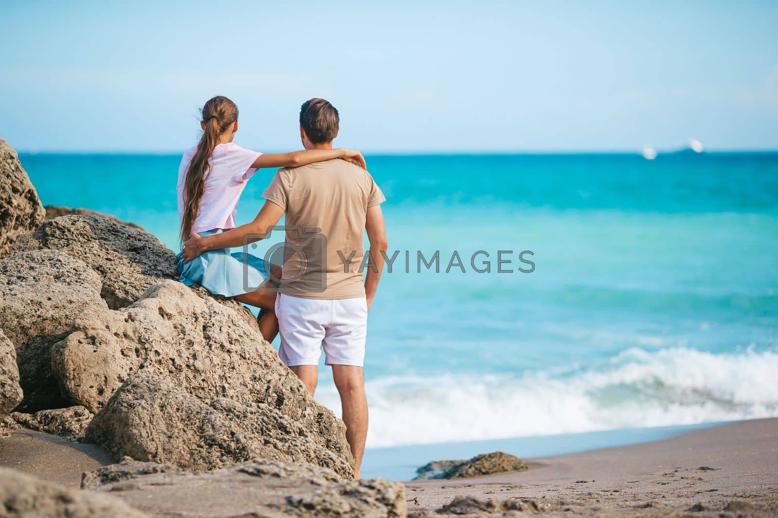 Royalty free image of Family of young father and cute daughter enjoy the view of the sea on the beach by travnikovstudio