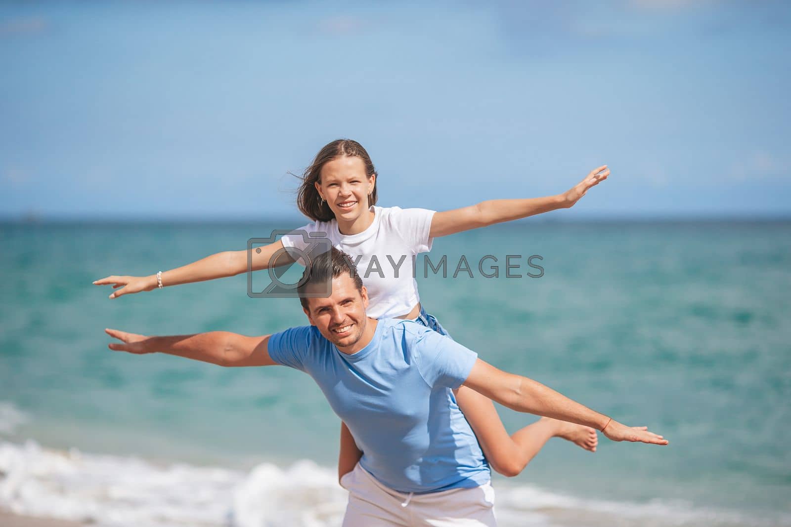 Royalty free image of Family of dad and daughter have fun together on the beach by travnikovstudio