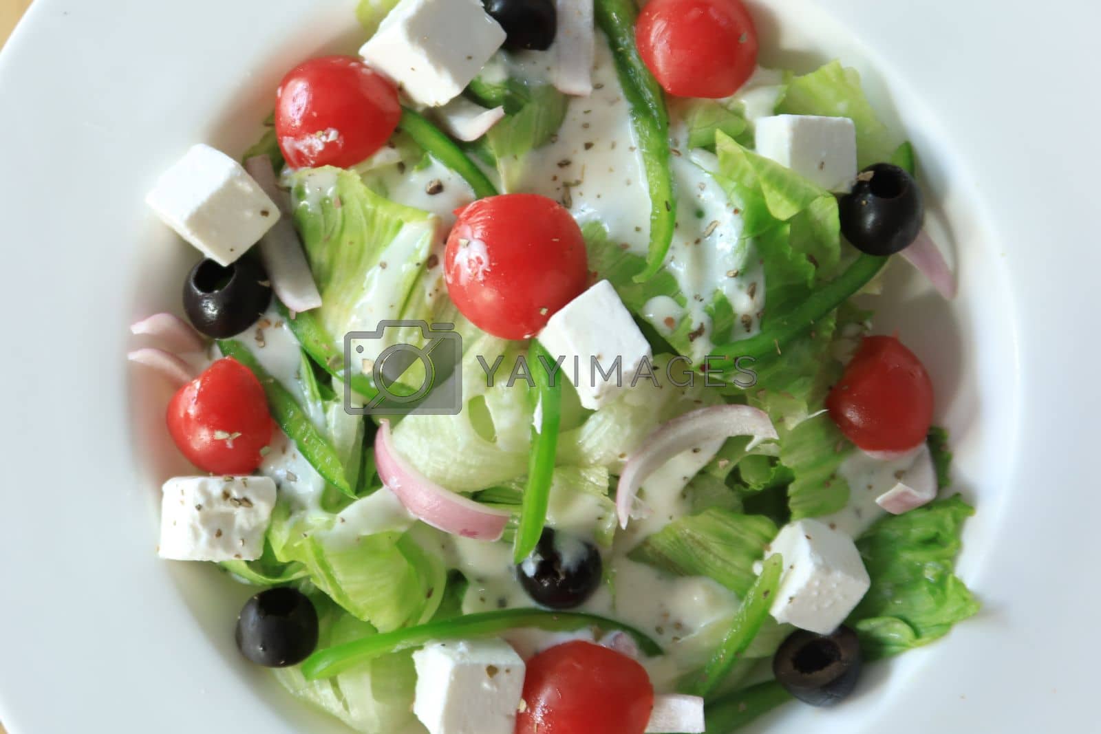 Royalty free image of Close up of greek salad in a bowl on table. by towfiq007
