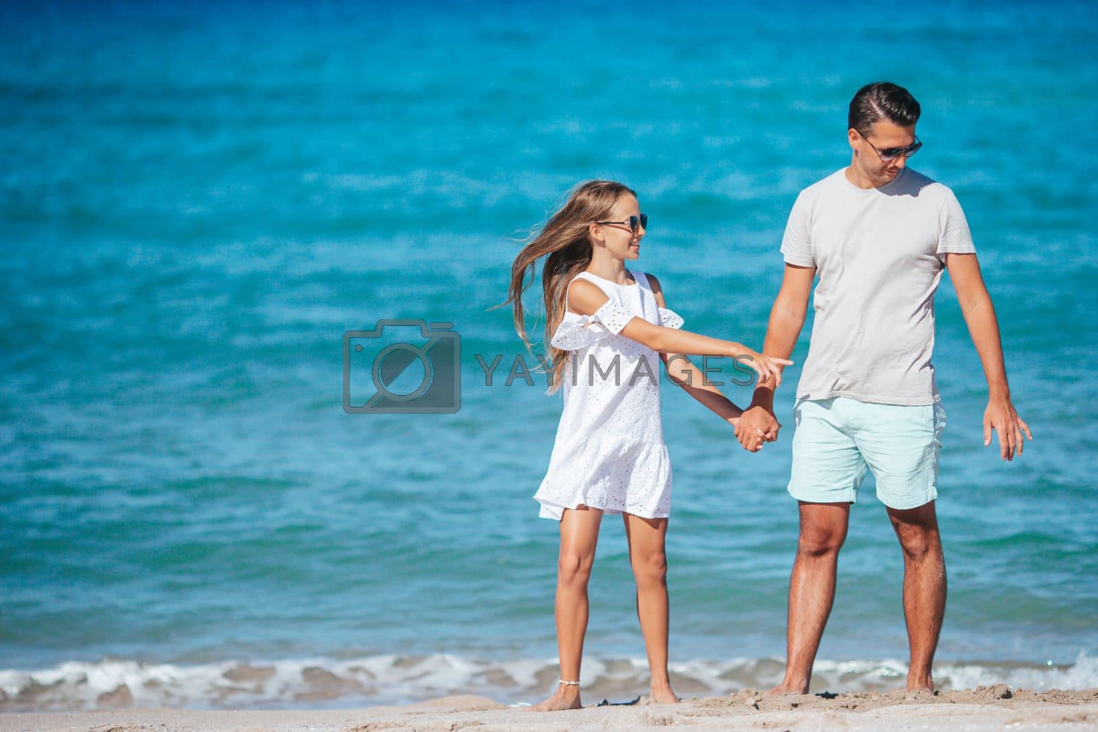 Royalty free image of Family of dad and daughter have fun together on the beach. Family vacation by travnikovstudio