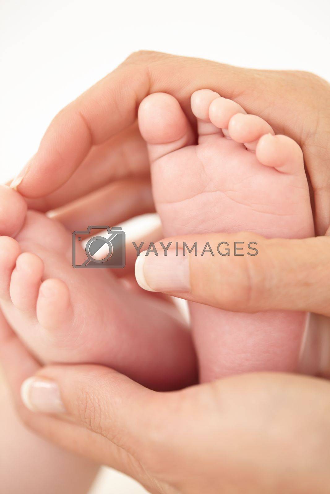 Royalty free image of Cradling tiny feet. Cropped close up shot of a mother holding her babies feet. by YuriArcurs