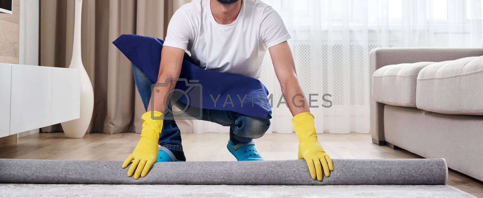 Royalty free image of Close up of man unrolling carpet. Cleaning service concept by Mariakray